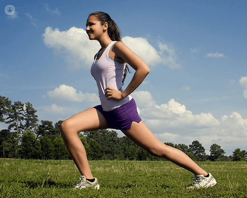 Woman is preparing to run with her runner outfit on a field